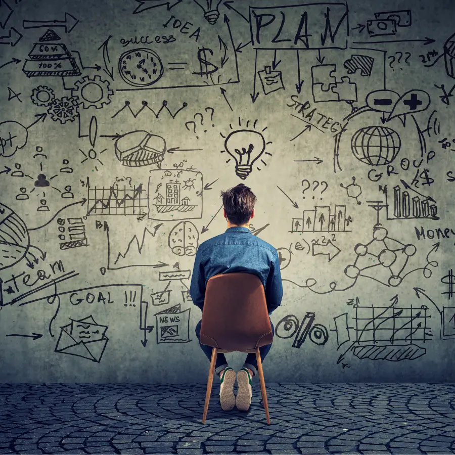 person facing wall with various planning related drawings