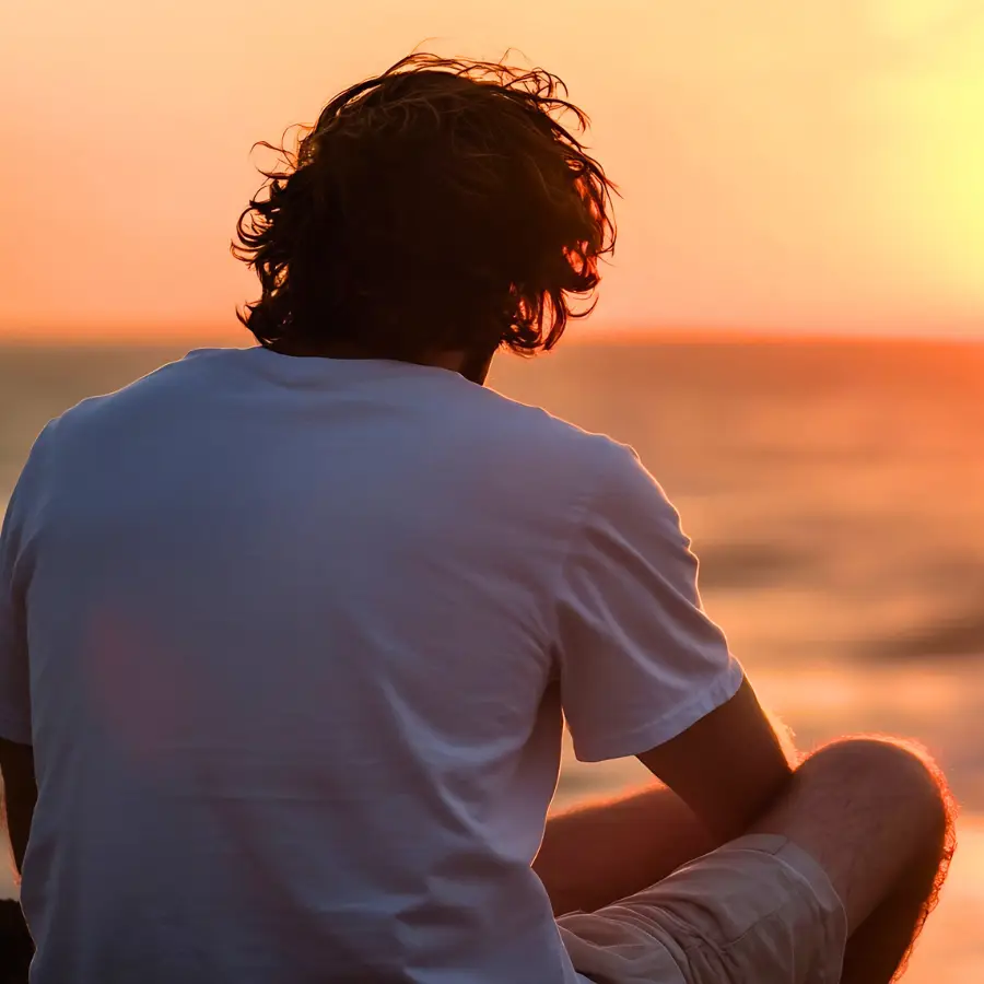 person facing sunset reflecting